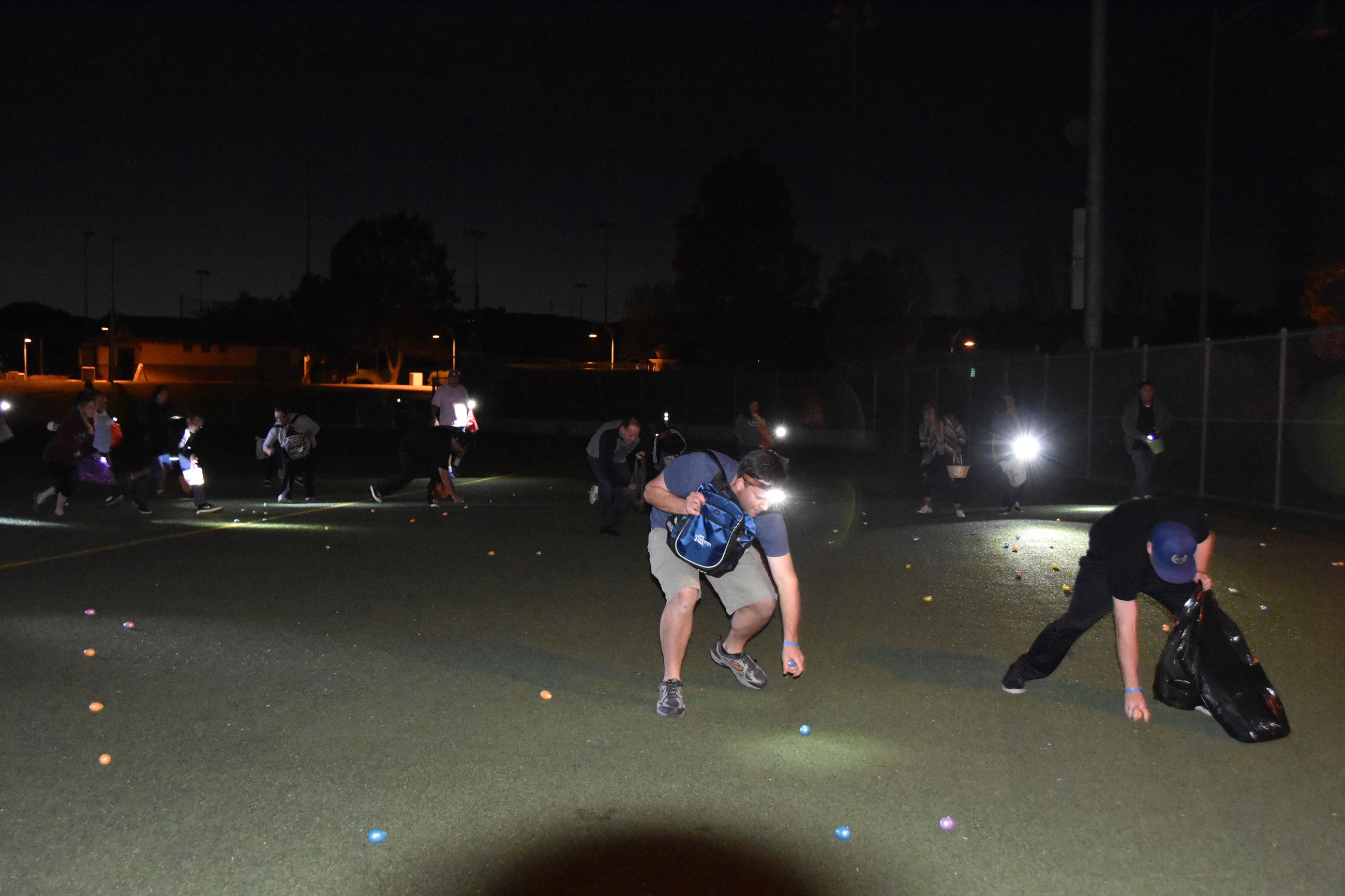 Adults hunt for eggs in the dark during Adult Easter Egg-Scramble.